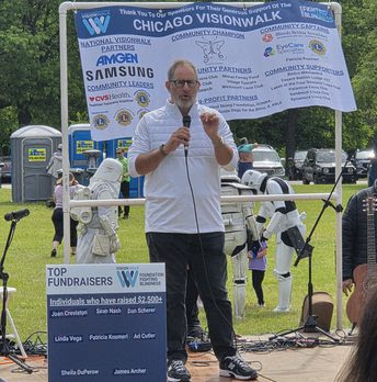 A man on stage announcing the events of the day