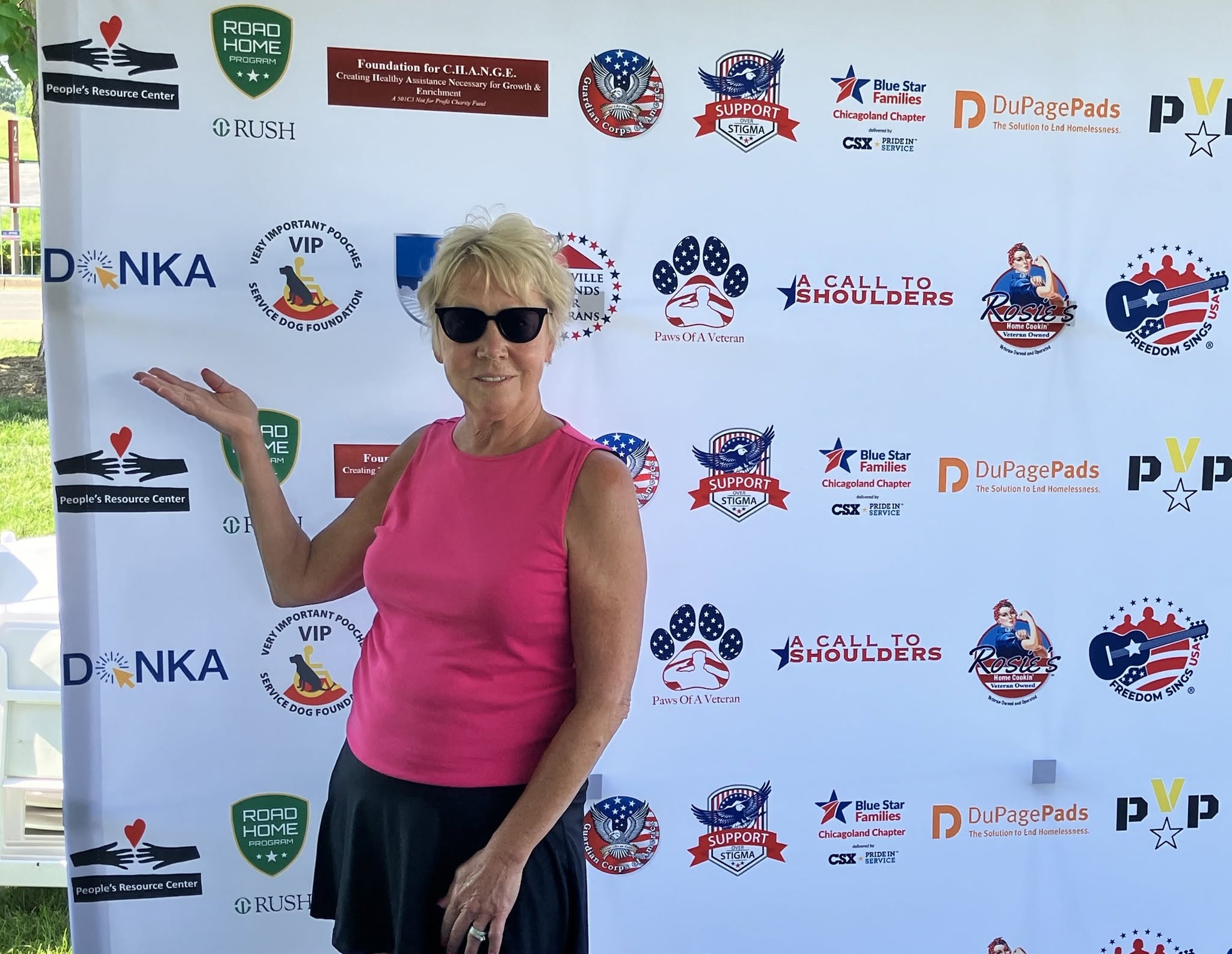 Leanne Vos in front of Rockin for Our Vets banner