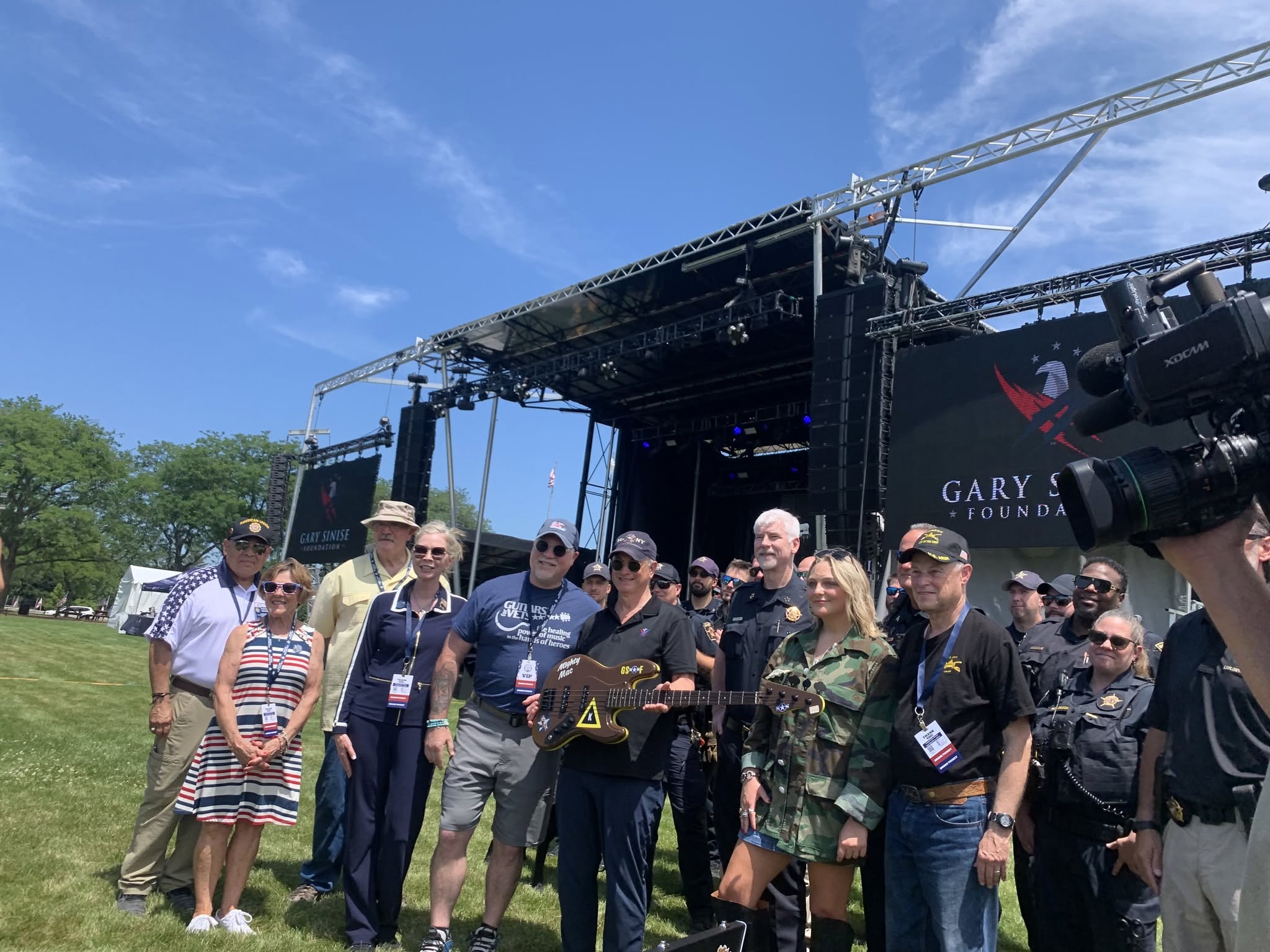 Photo of Gary Sinise and group with special guitar from Guitars for Vets