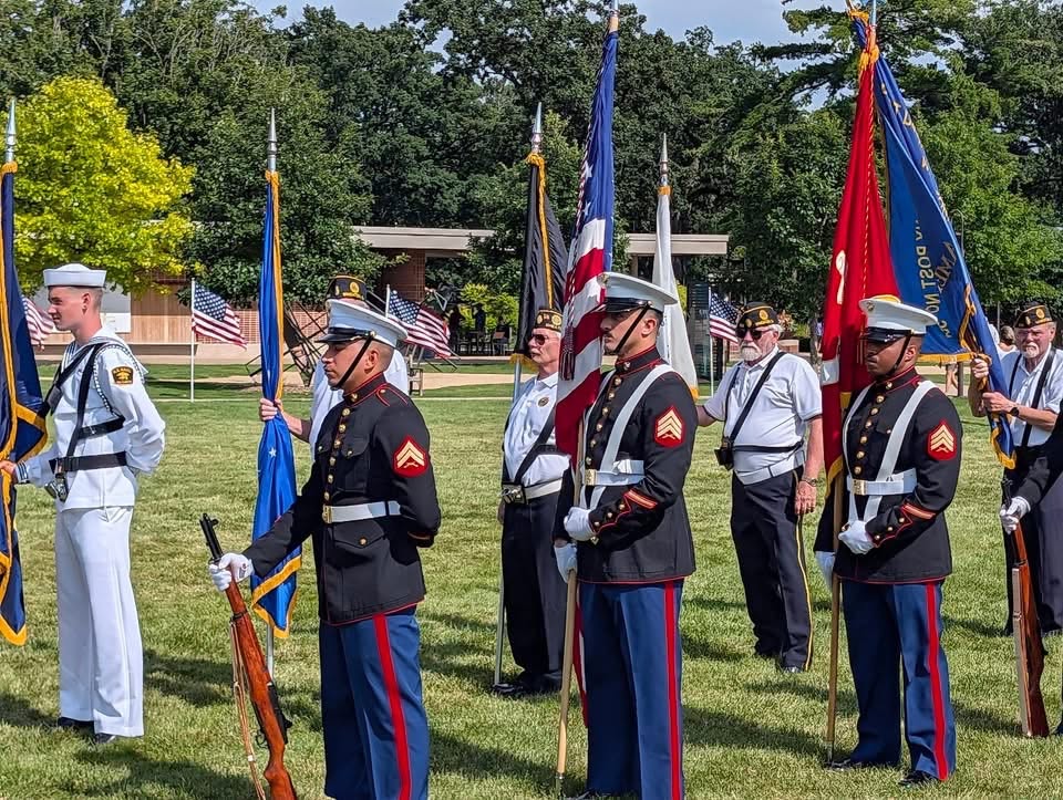 armed forces stand in formation with flags